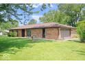 Side view of a beautiful brick ranch home with an attached garage and well-kept lawn at 10928 W Jackson St, Muncie, IN 47304