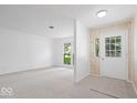 Bright and airy living room featuring neutral carpet, large windows, and stylish wall accents at 10928 W Jackson St, Muncie, IN 47304