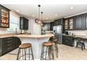 Modern kitchen features dark cabinets, granite countertops, stainless steel appliances, and a breakfast bar with seating at 117 Sawgrass Ct, Lebanon, IN 46052