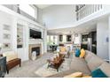 Open-concept living room with a fireplace, built-in shelving, and seamless transition to the kitchen and dining area at 117 Sawgrass Ct, Lebanon, IN 46052
