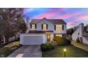 Charming two-story home featuring a well-manicured lawn and an attached two-car garage during sunset at 11961 Driftstone Dr, Fishers, IN 46037