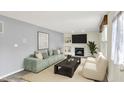 Bright living room features a modern sofa, fireplace, and natural light creating an inviting atmosphere at 11961 Driftstone Dr, Fishers, IN 46037