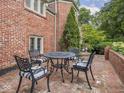 A brick patio features a table and chairs, set against the backdrop of a well-maintained yard at 1207 Pickwick Pl, Indianapolis, IN 46208