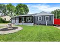 Charming one-story home with a grey exterior, covered porch and landscaped front yard at 121 Ursal Ln, Greenwood, IN 46143