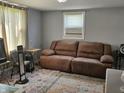 Living room features a large brown sofa, area rug, window with blinds at 1601 S Biltmore Ave, Muncie, IN 47302