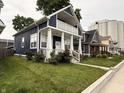 A charming two-story home featuring a covered porch, white columns, and green lawn, plus neighboring houses at 1720 Rembrandt St, Indianapolis, IN 46202
