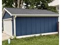 Garage featuring a blue siding, a white door, and trim, providing ample parking and storage space at 1720 Rembrandt St, Indianapolis, IN 46202
