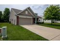 View of the exterior showcasing the two-car garage, and well-maintained lawn at 1792 Persimmon Grove Dr, Indianapolis, IN 46234