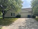 Spacious garage with double doors situated alongside a well-maintained lawn and a long driveway at 19409 Mimosa Ct, Noblesville, IN 46060