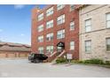 Brick apartment building with covered entryway, adjacent parking lot and professionally landscaped grounds at 2105 N Meridian St # 203, Indianapolis, IN 46202