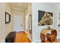 Inviting hallway with warm wood floors, bench seat, console table and art at 2105 N Meridian St # 203, Indianapolis, IN 46202