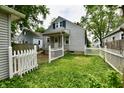 The beautiful backyard features a charming white picket fence and lush green lawn at 313 N 16Th Ave, Beech Grove, IN 46107