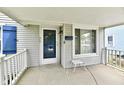 Covered front porch with charming details, including a stool, railing, and traditional siding at 313 N 16Th Ave, Beech Grove, IN 46107