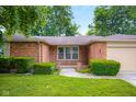 Attractive brick home with trimmed shrubs and well-manicured lawn near the front entrance at 3235 Flintwood Dr, Columbus, IN 47203