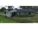 Cozy home with stone facade, shed, and large backyard with tall grass and a chainlink fence at 4631 Terrace Ave, Indianapolis, IN 46203