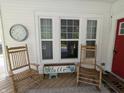 Inviting front porch with rocking chairs, a seasonal display, and a red front door at 4740 Milton St, Coatesville, IN 46121