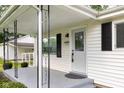Inviting front porch leading to a charming entrance, enhanced by a well-lit exterior and manicured shrubs at 533 Patterson Rd, Columbus, IN 47203