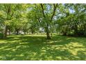 Spacious backyard surrounded by mature trees, perfect for outdoor activities at 5719 N Frontage Rd, Fairland, IN 46126