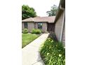 Landscaped walkway leading to the home's entrance, adorned with vibrant flowers and lush greenery at 5943 Red Maple Dr, Indianapolis, IN 46237