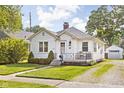 Lovely exterior showcases a manicured lawn, a quaint front porch, and timeless architectural elements at 6045 Crittenden Ave, Indianapolis, IN 46220