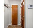 Hallway with tiled floors, coat hooks and wooden doors gives way to the rest of the house at 6045 Crittenden Ave, Indianapolis, IN 46220