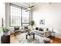 Bright living room featuring hardwood floors, a large window, a ceiling fan and modern furnishings at 624 E Walnut St # 48, Indianapolis, IN 46204