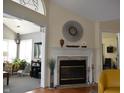Cozy living room featuring a fireplace with decorative mantle and adjacent entryway into another seating area at 7357 Lake Lakota Dr, Indianapolis, IN 46217