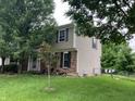 Image shows the side exterior of a two-story home with siding, black shutters, and a fenced yard at 7667 Madden Ln, Fishers, IN 46038