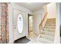 Bright foyer featuring a staircase and a view into the bathroom at 7724 Eagle Valley Pass, Indianapolis, IN 46214