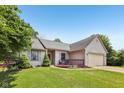 Inviting single-story house with a cozy front deck, green lawn, and attached garage at 7831 Bayridge Dr, Indianapolis, IN 46236