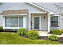 Home featuring a covered front porch, an upgraded door, and charming landscaping at 8247 Cape N Dr, Indianapolis, IN 46256
