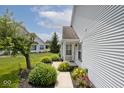 Landscaped front yard with sidewalk leading to a home featuring attractive siding at 8247 Cape N Dr, Indianapolis, IN 46256