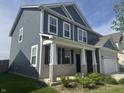 Attractive two-story home with a covered porch, blue siding, and manicured landscaping at 8969 Faulkner Dr, Indianapolis, IN 46239