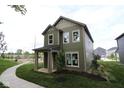 Stunning view of a two-story home with green siding, a well-kept lawn, and a sidewalk at 9520 Bauhaus Way, Indianapolis, IN 46240
