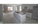 Unfinished kitchen features white cabinets, an island, and a large window for natural light at 9520 Bauhaus Way, Indianapolis, IN 46240