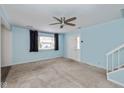 Inviting living room with neutral carpeting, blue painted walls, and a ceiling fan at 10016 Penrith Dr, Indianapolis, IN 46229