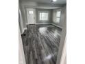 Bright living room features new gray wood flooring, fresh paint, and natural light from updated windows at 1006 Hurricane St, Franklin, IN 46131