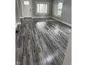 Bright living room features new gray wood flooring, fresh paint, and natural light from updated windows at 1006 Hurricane St, Franklin, IN 46131