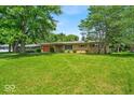 Single-story home with a large front lawn and mature trees providing shade at 108 Bennett Rd, Carmel, IN 46032