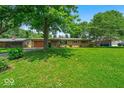 Well-kept single-story home featuring a lush green lawn and mature shade trees at 108 Bennett Rd, Carmel, IN 46032