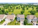 Aerial view of a home in a lush, green neighborhood showcasing mature trees, well-maintained lawns, and nearby golf course at 1314 Old Heritage Pl, Greenwood, IN 46143