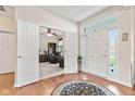 Inviting foyer with hardwood flooring, transom windows, and a view of a living room at 13327 Hockley Dr, Fishers, IN 46037