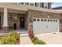 Inviting front entrance features a brick facade, colorful flowers, and a black door with a decorative wreath at 14442 Treasure Creek Ln, Fishers, IN 46038