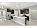 A spacious kitchen with dark cabinets, stainless steel appliances, and a large island with a sink at 14474 Treasure Creek Ln, Fishers, IN 46038