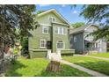 Front view of green two-story home with a well-manicured lawn at 3307 N College Ave, Indianapolis, IN 46205