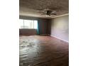 Spacious living room features hardwood floors, large window and ceiling fan, ready for personalized updates and comfortable living at 3320 E 26Th St, Indianapolis, IN 46218