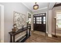 Welcoming foyer with hardwood floors, console table, decorative art, and large front door at 3429 Woodham Pl, Carmel, IN 46033