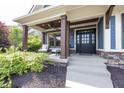 Inviting front porch with stylish seating and dark brown support pillars at 3429 Woodham Pl, Carmel, IN 46033