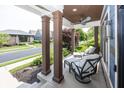 Relaxing front porch seating, supported by dark brown support pillars at 3429 Woodham Pl, Carmel, IN 46033