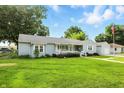 Beautiful single-story home with lush green lawn, a cozy front porch, and light blue exterior siding at 409 Hanley St, Plainfield, IN 46168
